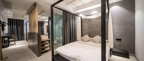 Un dormitorio moderno con cama con dosel, un armario de madera y un separador de vidrio.