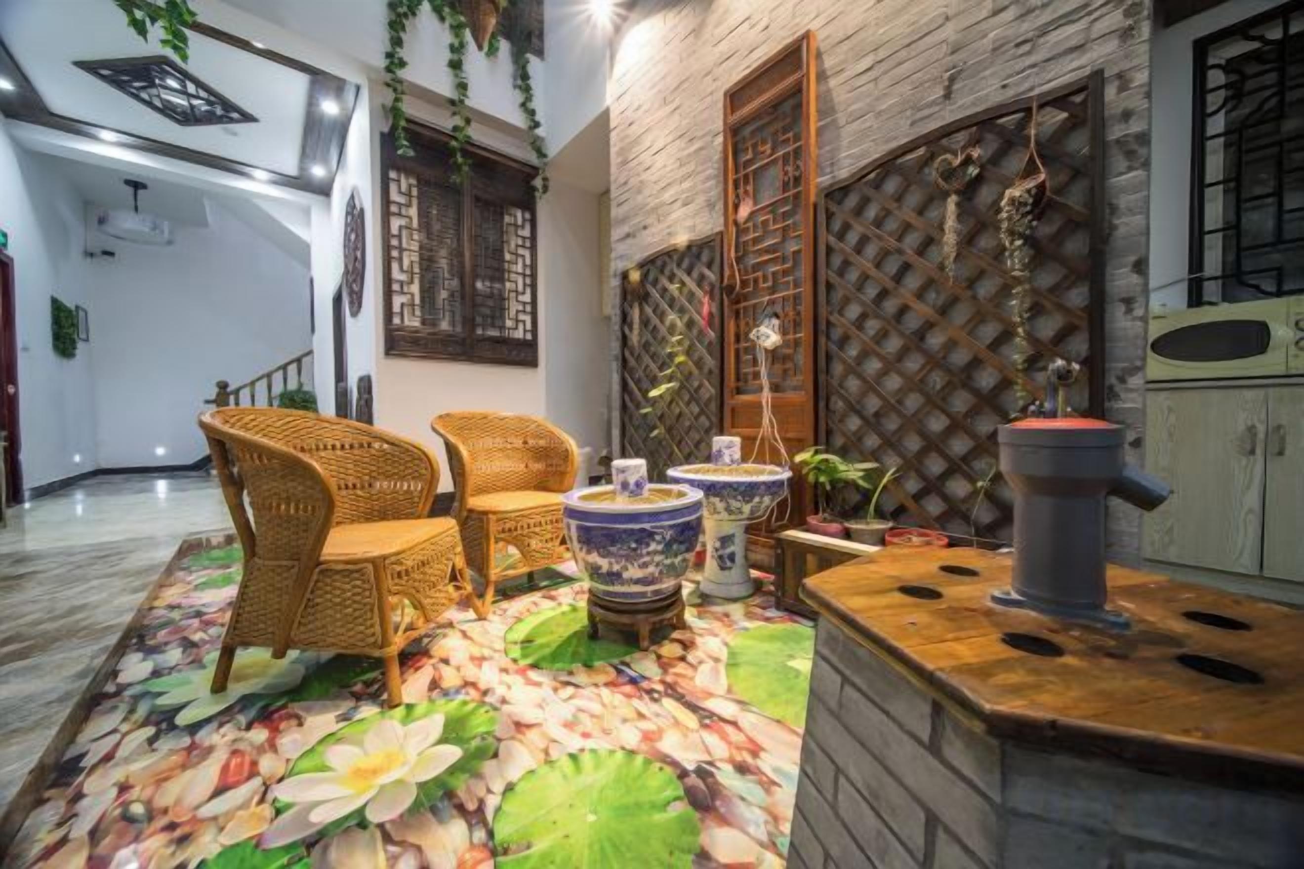 A room with wicker furniture, a decorative rug, and a traditional stove.