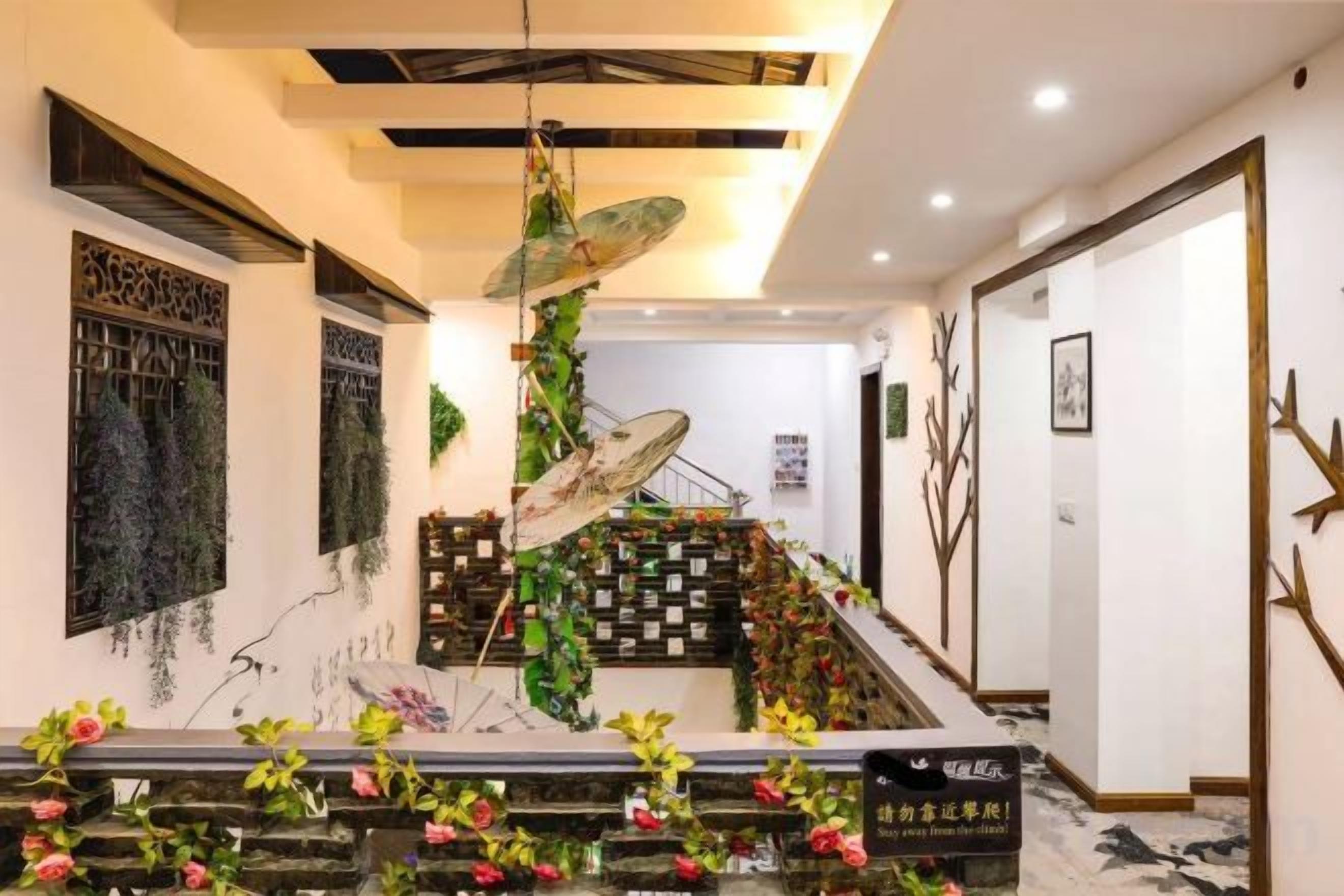 Een hotel lobby met een trap, decoratieve wandkunst en een receptiebalie.