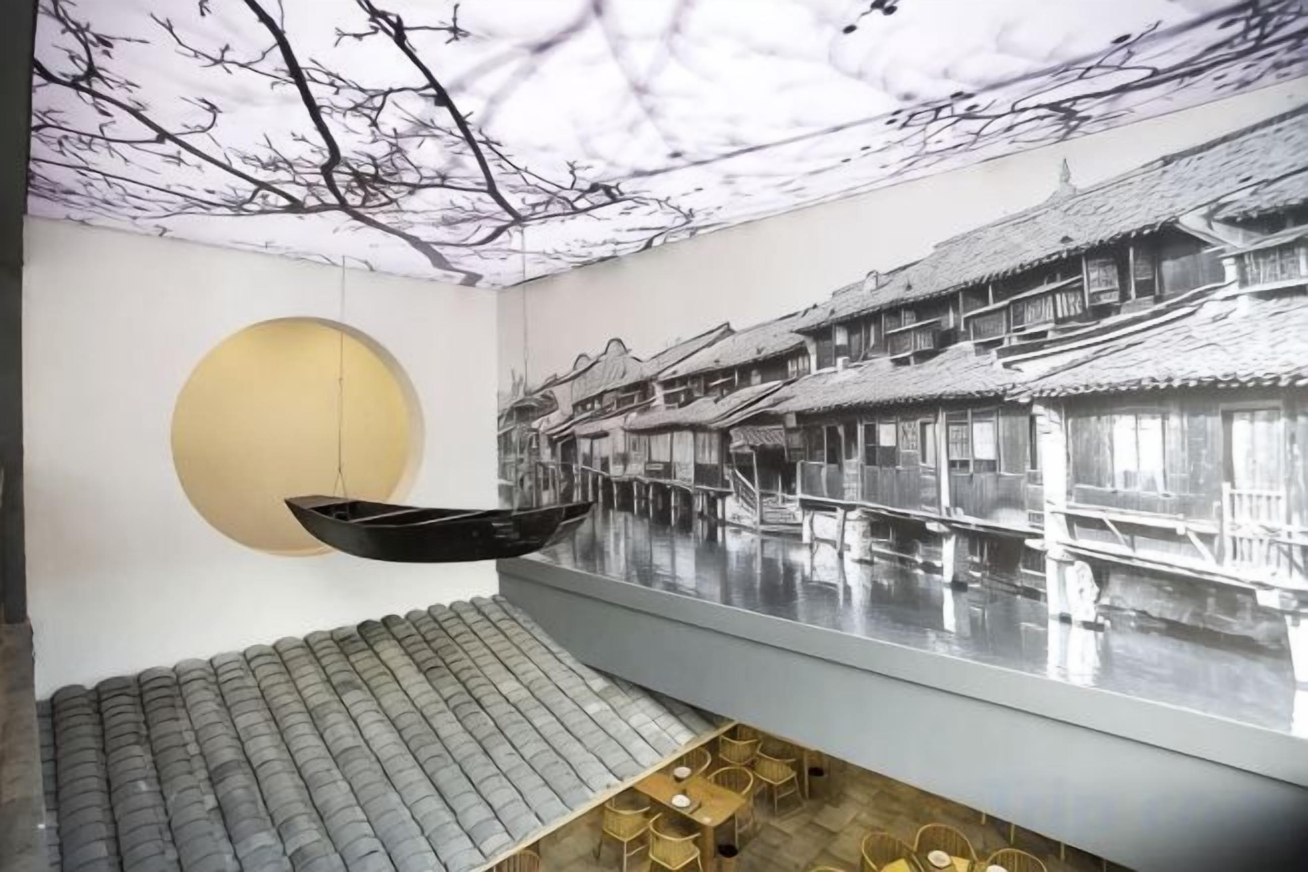 A room with a hanging boat, a circular wall feature, and a mural of traditional buildings.