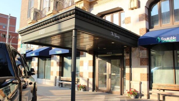 A building with a covered entrance, numbered 123, and a sign for 'The Youngest'.