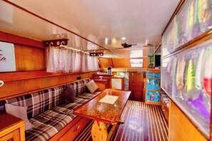 Cozy cabin interior with a wooden bench, table, and shelf, offering a warm and inviting space.