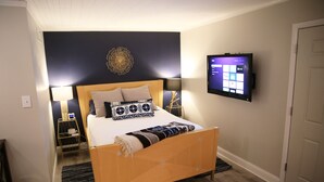 Une chambre d’hôtel bien aménagée, avec un lit, des lampes de chevet, un téléviseur fixé au mur et un élément décoratif mural.