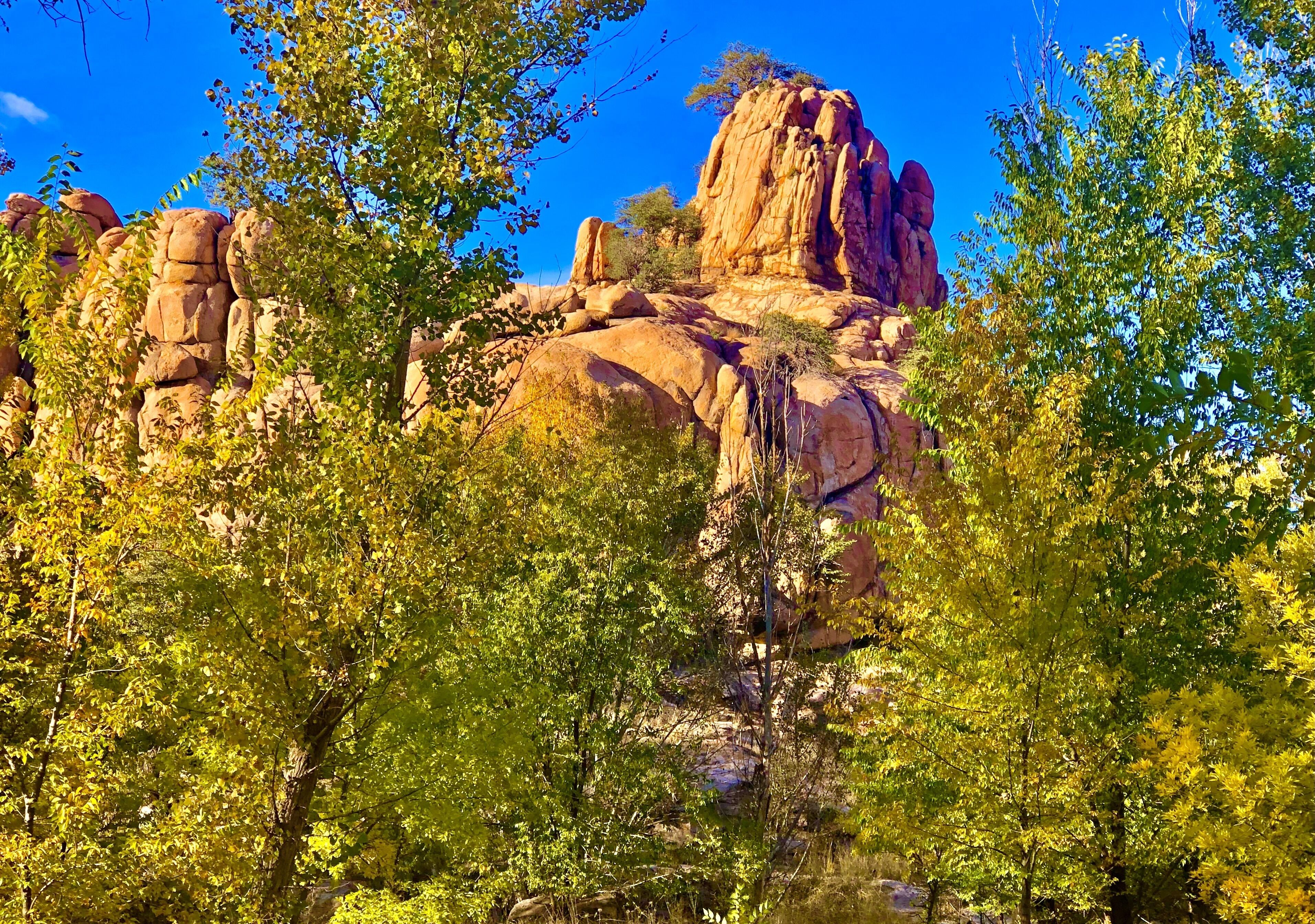 A natural landscape with prominent rock formations and dense green foliage.