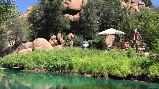 A natural landscape with a clear water body, large rock formations, and a seating area with an umbrella. - Heaven on Earth Retreat's Spectacular Suite in Prescott's Gorgeous Granite Dells (Prescott)