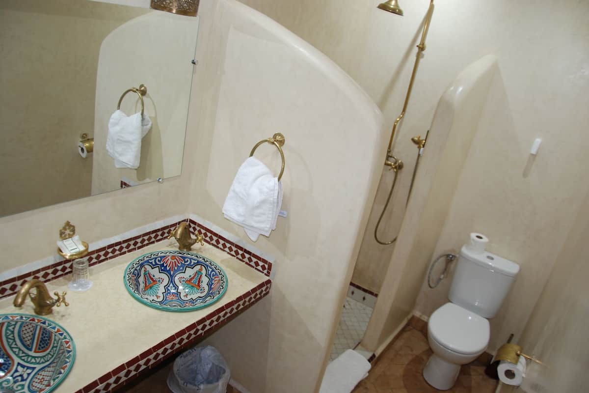 A bathroom with a sink, mirror, and toilet.