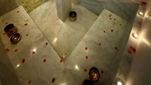 A marble-floored room with a central pillar, a small window, and a decorative light fixture. - RIAD MAGNOLIA (Marrakech)