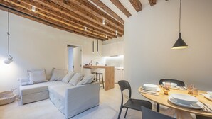 Un espace de vie moderne comprenant un canapé, une table à manger et un coin cuisine.