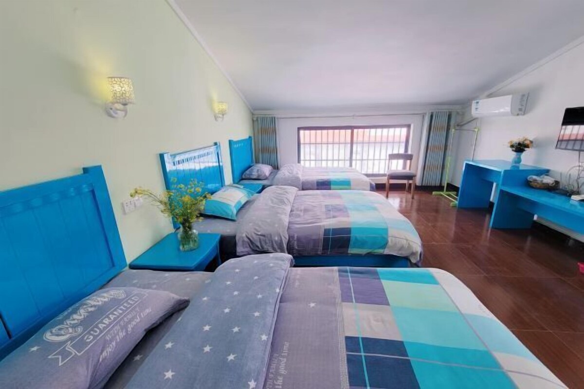 Ein Hotelzimmer mit zwei Betten, einem Schreibtisch und einem Fenster.