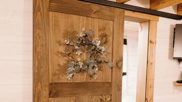 A wooden door with a decorative wreath, a visible handle, and a sliding mechanism.