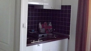 A compact kitchen with white cabinets, a black countertop, and a tiled backsplash. - Cozy Apartment 16 With Double bed Sleeper Couch (Split)