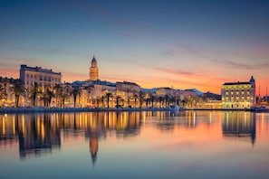 A waterfront cityscape with a prominent tower and buildings along the shore.