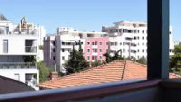 A view of a residential area with multi-story buildings, some with balconies, and a clear blue sky. - Cozy Apartment 16 With Double bed Sleeper Couch (Split)