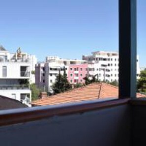 A view of a residential area with multi-story buildings, some with balconies, and a clear blue sky. - Cozy Apartment 16 With Double bed Sleeper Couch (Split)