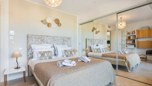 Une chambre moderne avec un grand lit, une table de chevet, un miroir et une bibliothèque.