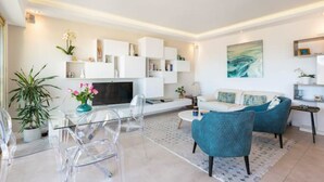 Un salon moderne avec un téléviseur à écran plat, un canapé et une table basse.