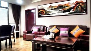 Una sala moderna con un conjunto de sofás, una mesa de centro y un cuadro abstracto grande en la pared.