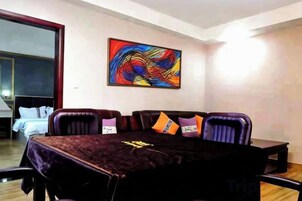 Uma sala de conferência com uma mesa escura, várias cadeiras e uma pintura abstrata colorida na parede.