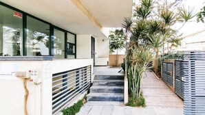 A corridor with a staircase leading to a building entrance, surrounded by plants and a gated area. - Kalisher Ophrys in Tel Aviv-yafo (Tel Aviv)