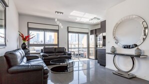 Ein modernes Wohnzimmer mit einer Ledersofa, einem runden Couchtisch und einem großen Spiegel an der Wand.