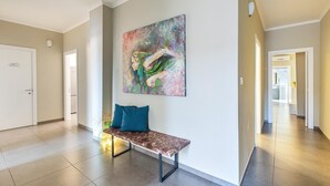 A hallway with a bench, a colorful abstract painting, and a door labeled "SILVERADO". - 2674 B&B Albatro - Camera Tripla (Taviano)