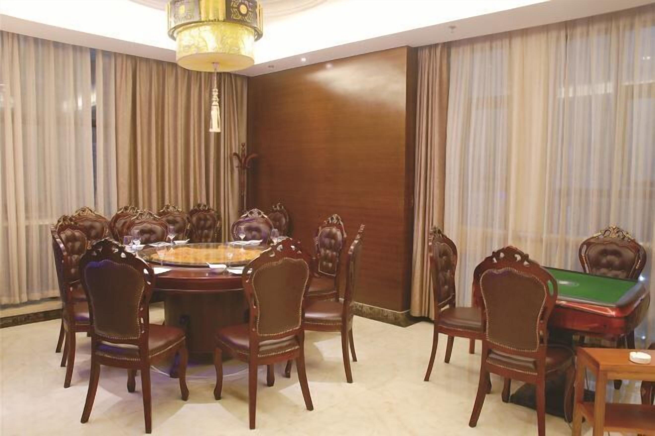 Un comedor con una mesa redonda, sillas y una mesa de billar.
