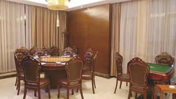 Un comedor con una mesa redonda, sillas y una mesa de billar.