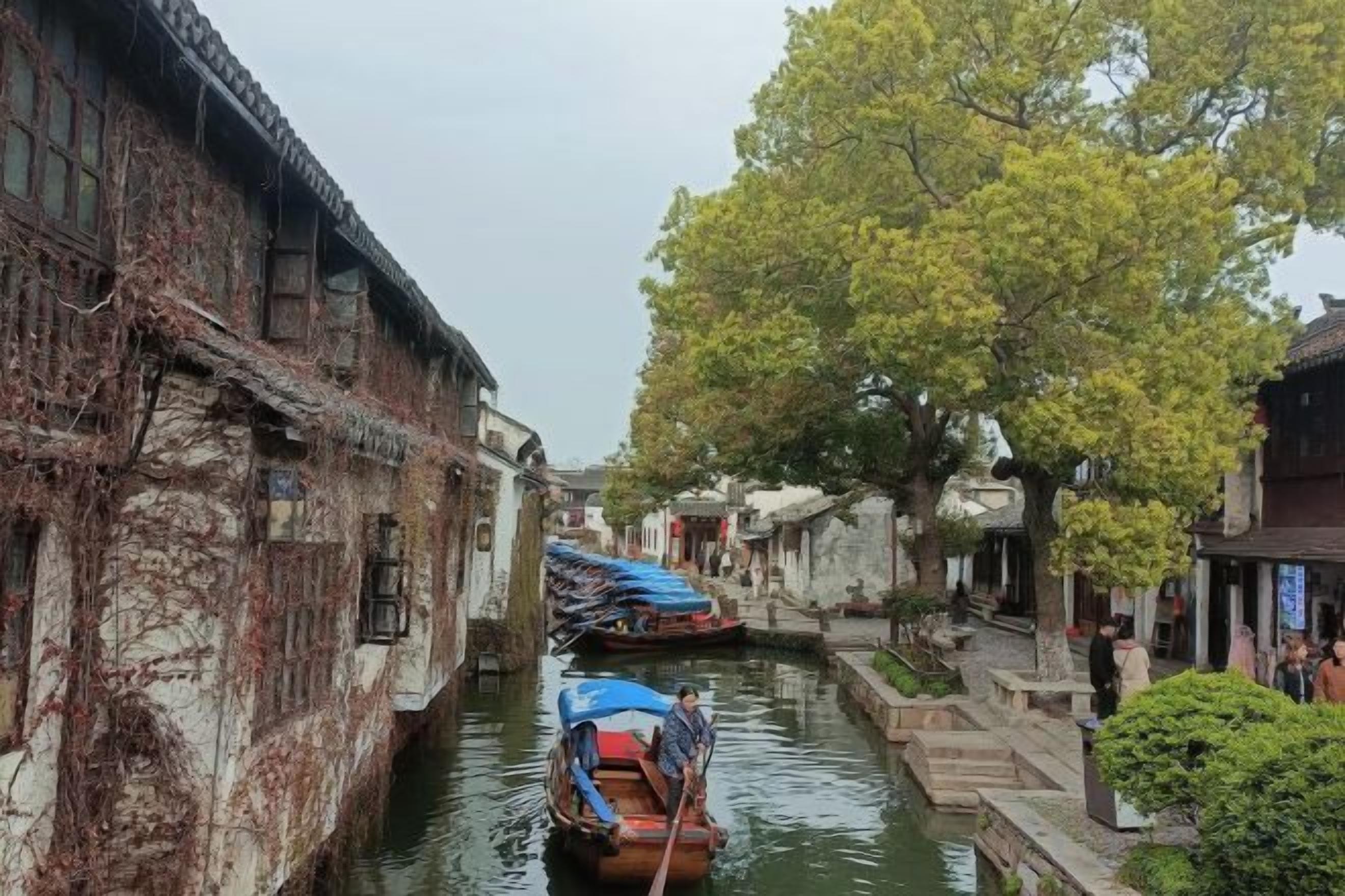 Um canal estreito ladeado por edifícios tradicionais, com um barco atracado ao centro.