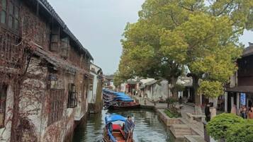 Um canal estreito ladeado por edifícios tradicionais, com um barco atracado ao centro.