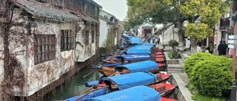 A narrow waterway lined with traditional boats and buildings.