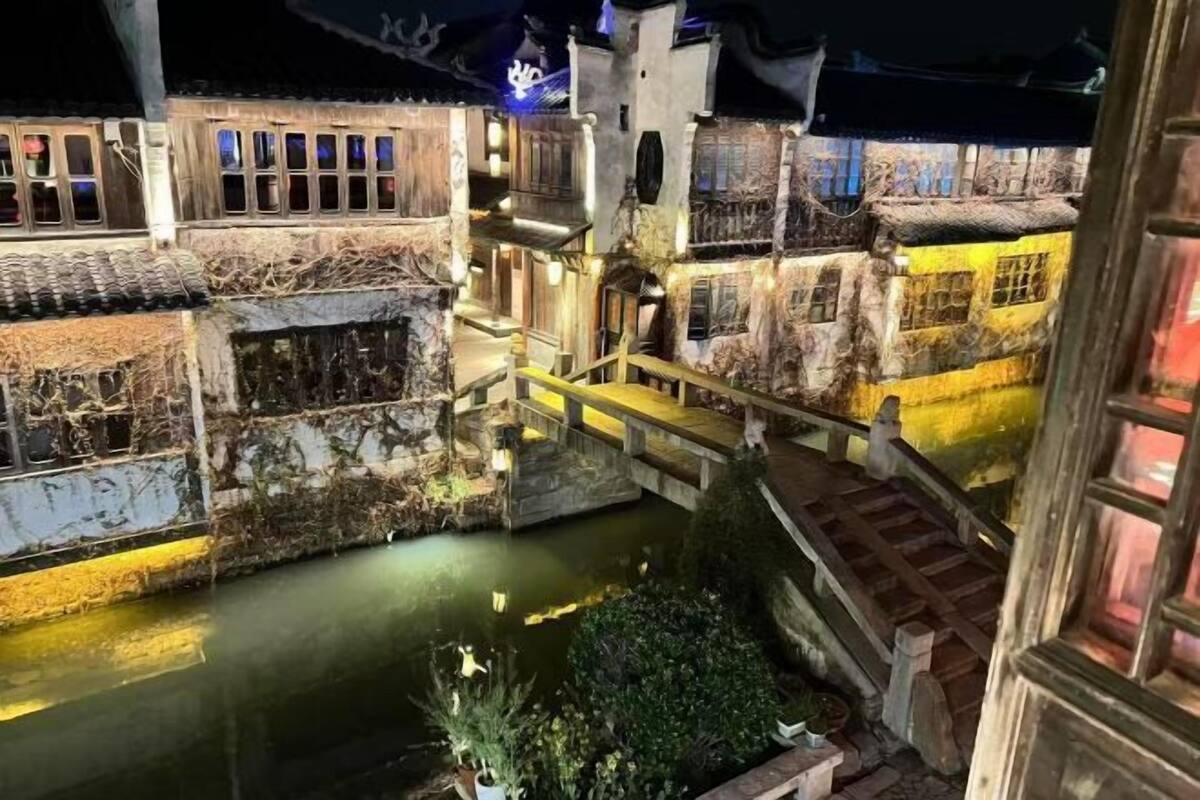 A model of a traditional village with narrow waterways, wooden bridges, and buildings with intricate designs.