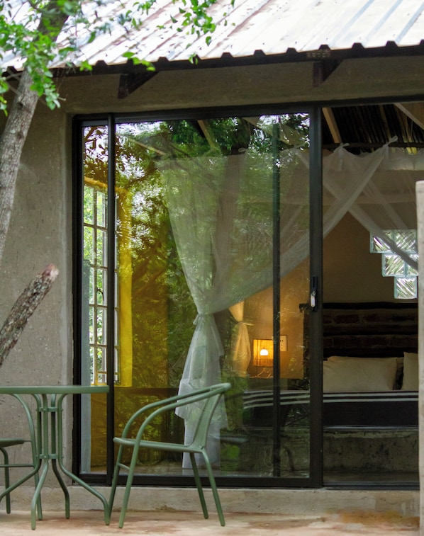 A room with a sliding glass door, a bed, and a chair.