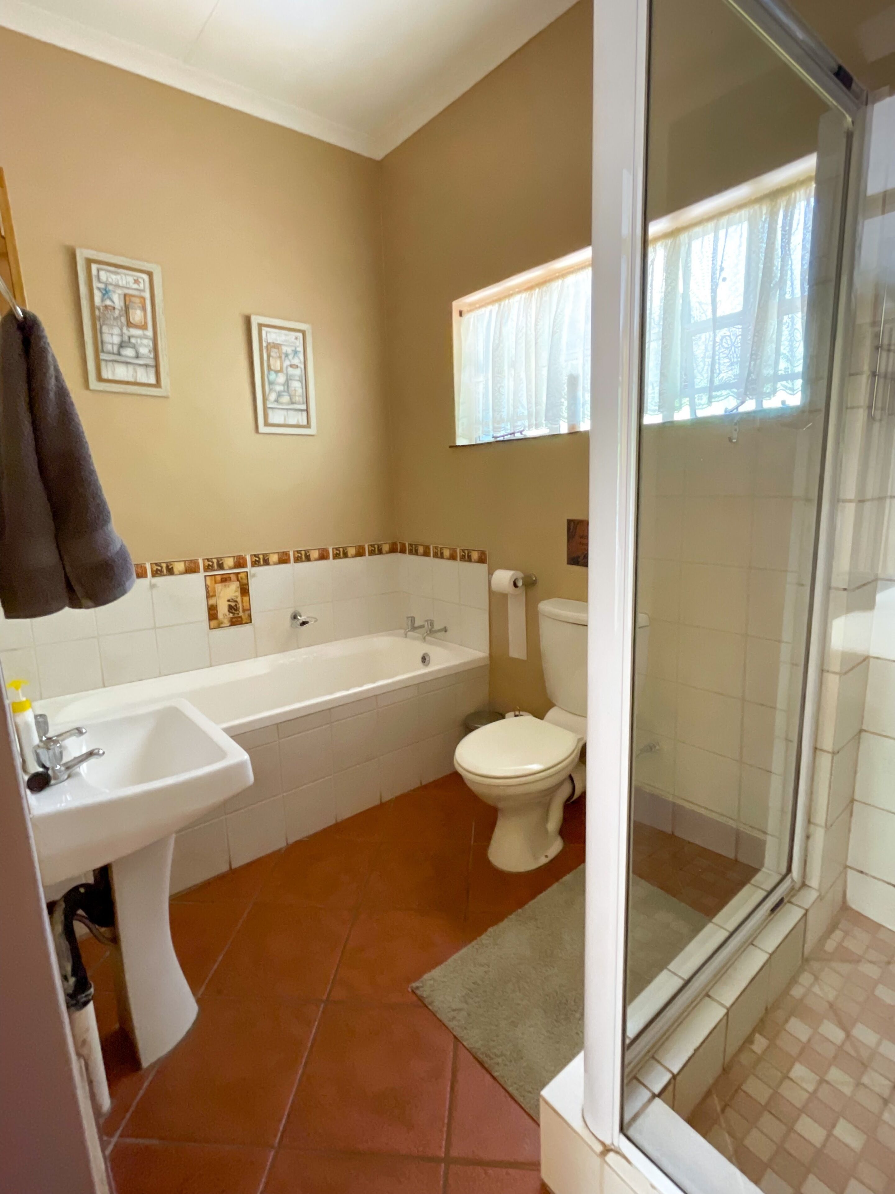 Un baño con lavamanos, bañera, inodoro y cabina de ducha de vidrio.