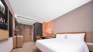 A modern hotel room with a large bed, a desk, and a television. - Xingye International Hotel (Yiwu International Trade City) (Yiwu)