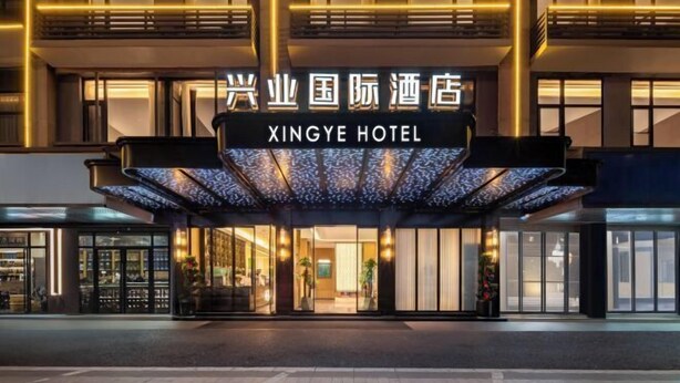 The exterior of Xingye Hotel with a modern facade, large glass windows, and a prominent entrance. - Xingye International Hotel (Yiwu International Trade City) (Yiwu)