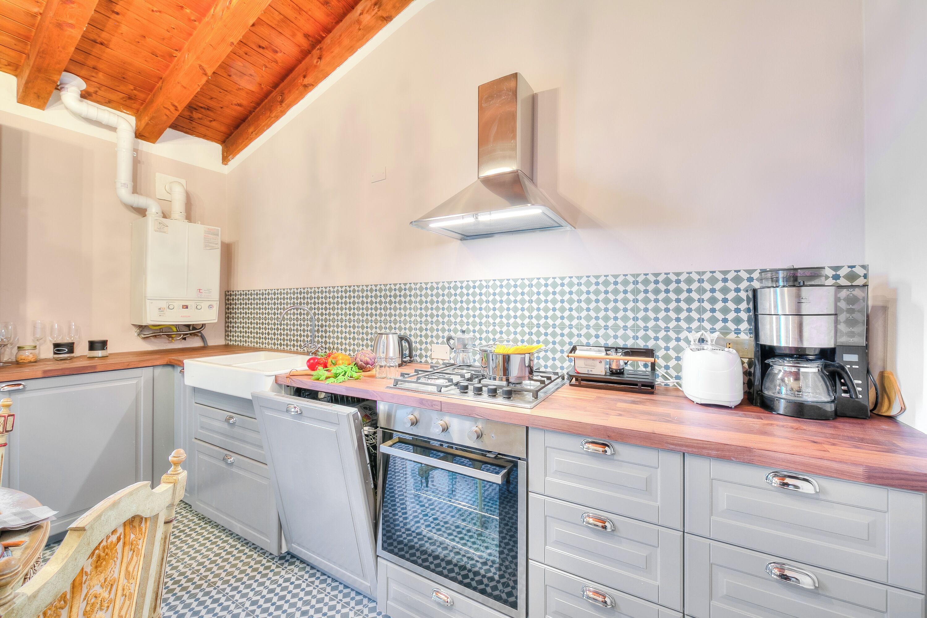 A kitchen with a stove, oven, and coffee maker.