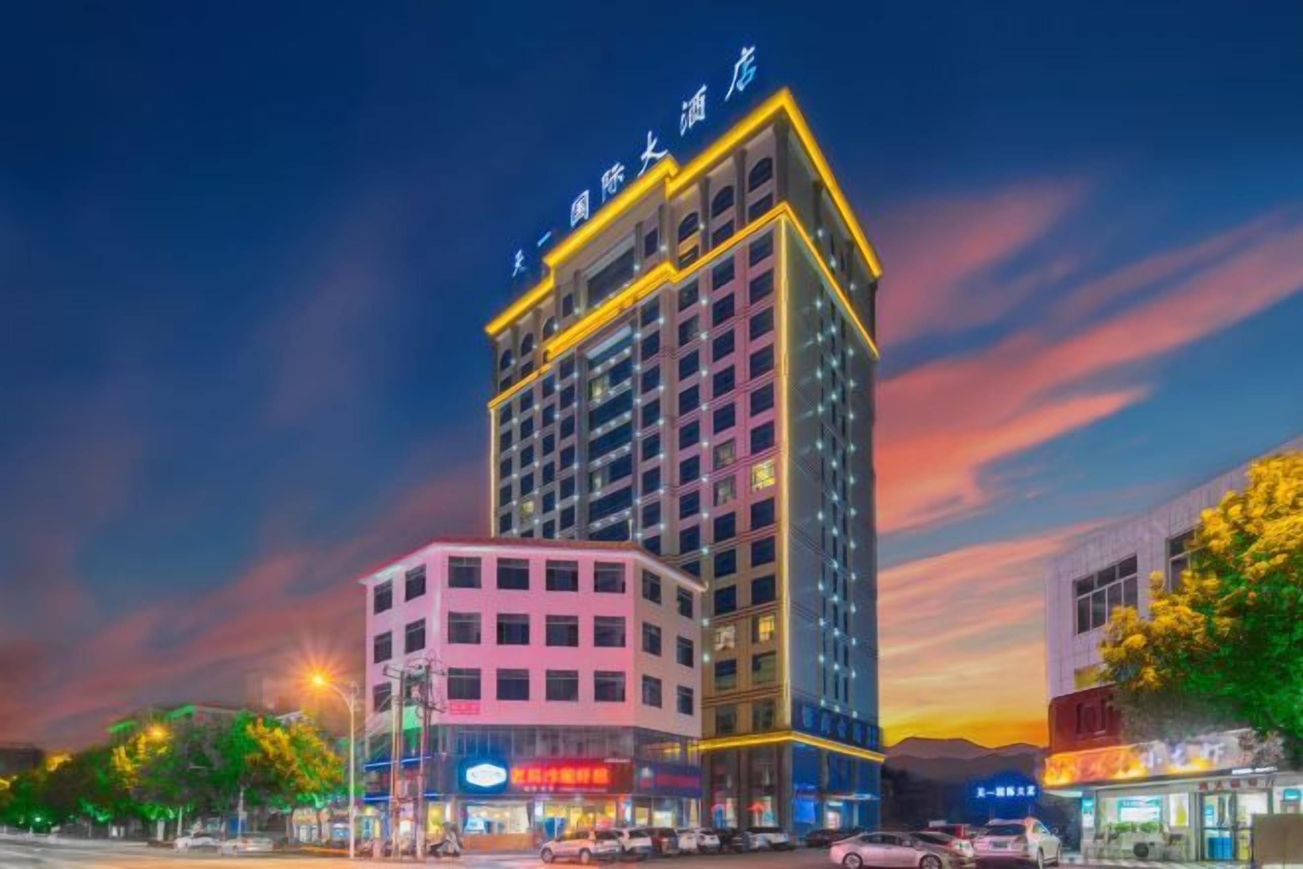 Ein mehrstöckiges Hotel mit einer auffälligen Schilderfassade, mehreren Etagen mit Fenstern und einem Ladenbereich im Erdgeschoss.