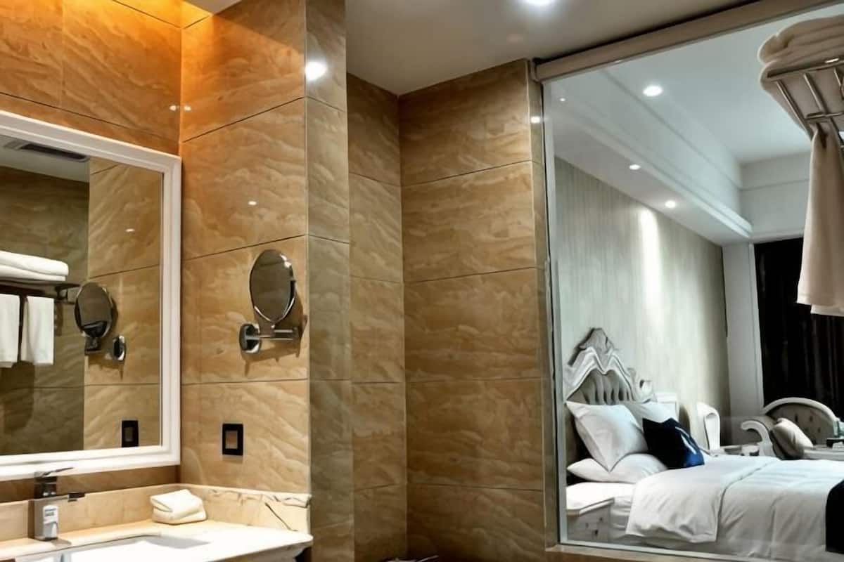 Een moderne badkamer met een grote spiegel, een wastafel en een douchecabine met glazen wanden.