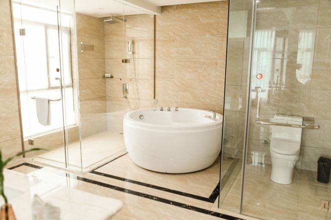 A modern bathroom with a glass-enclosed shower, a freestanding bathtub, and a toilet.