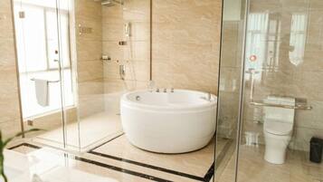 A modern bathroom with a glass-enclosed shower, a freestanding bathtub, and a toilet.