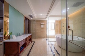 A modern bathroom with a large bathtub, a vanity with a mirror, and a glass shower enclosure. - Tianyi International Hotel (Jianghua)