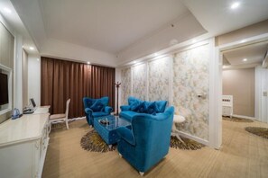 A modern living room with a sofa set, a coffee table, and a TV. - Tianyi International Hotel (Jianghua)