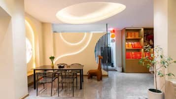 Un interior moderno con comedor, escalera y estantería.