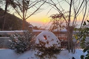 A snow-covered landscape with a sunset in the background. - Mountain and Courtyard Homestay (Hengyang)