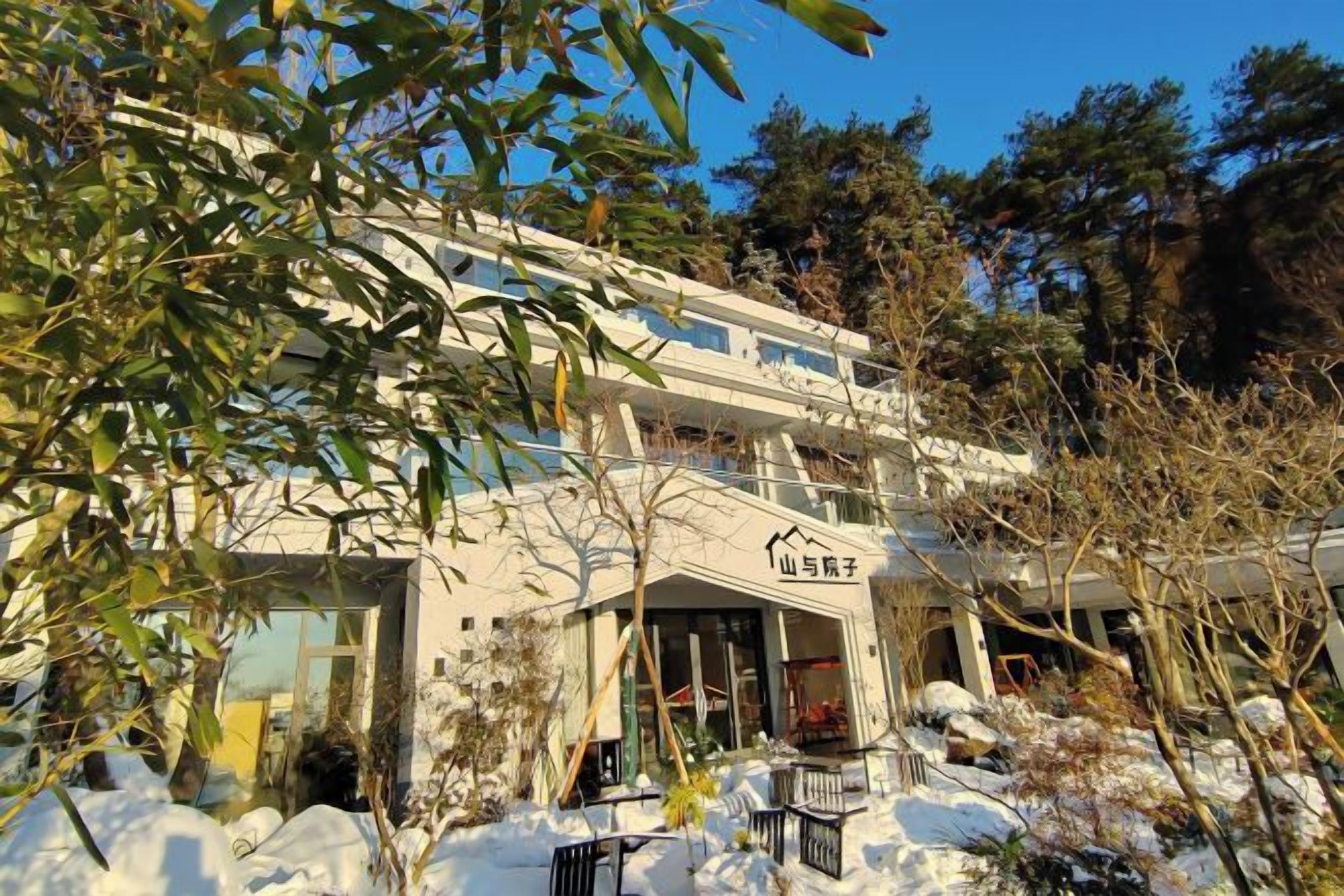 Un edificio de varios pisos con estilo arquitectónico tradicional, que presenta una entrada destacada y un balcón en el piso superior.