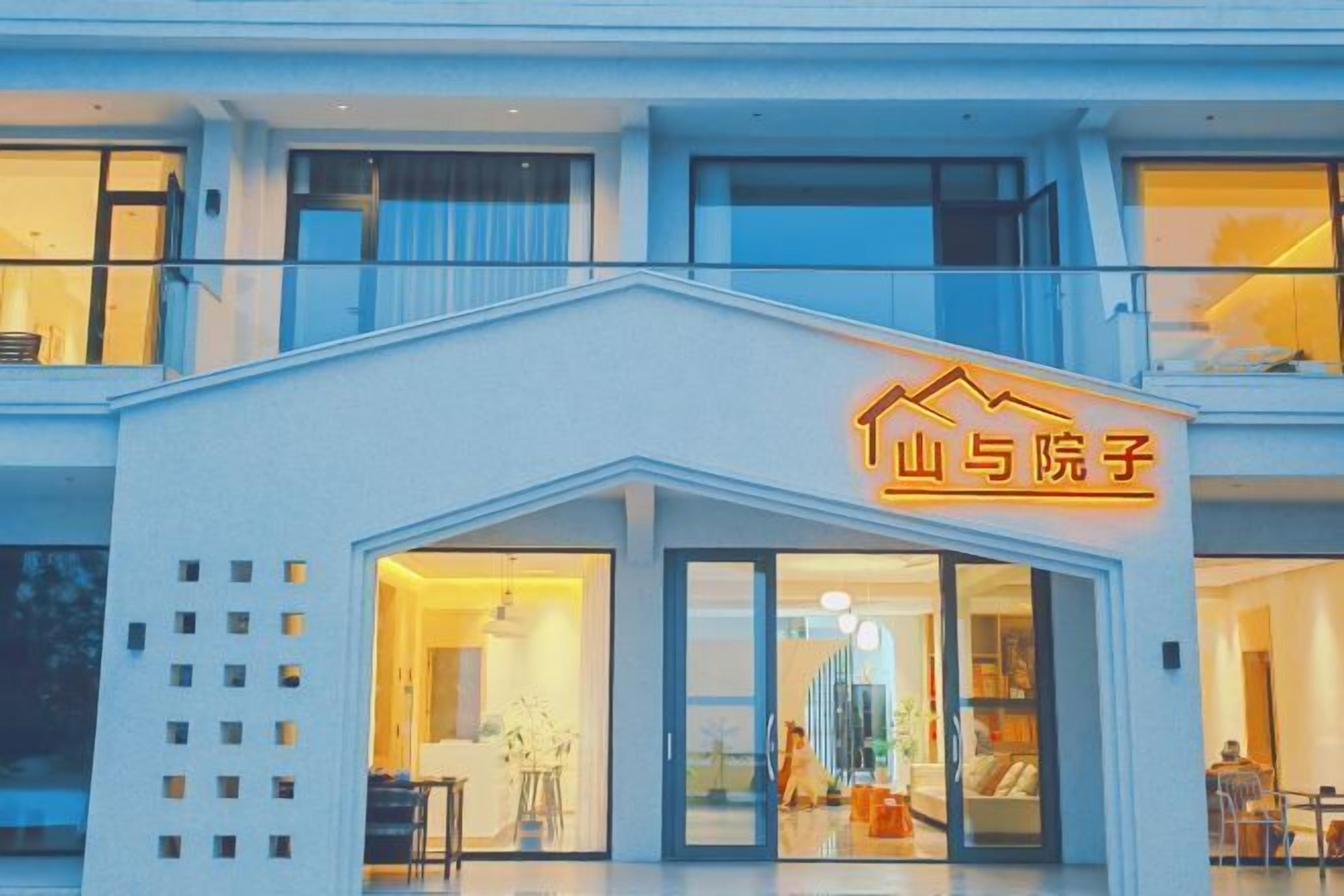Un hotel moderno con una entrada destacada y un letrero de neón.