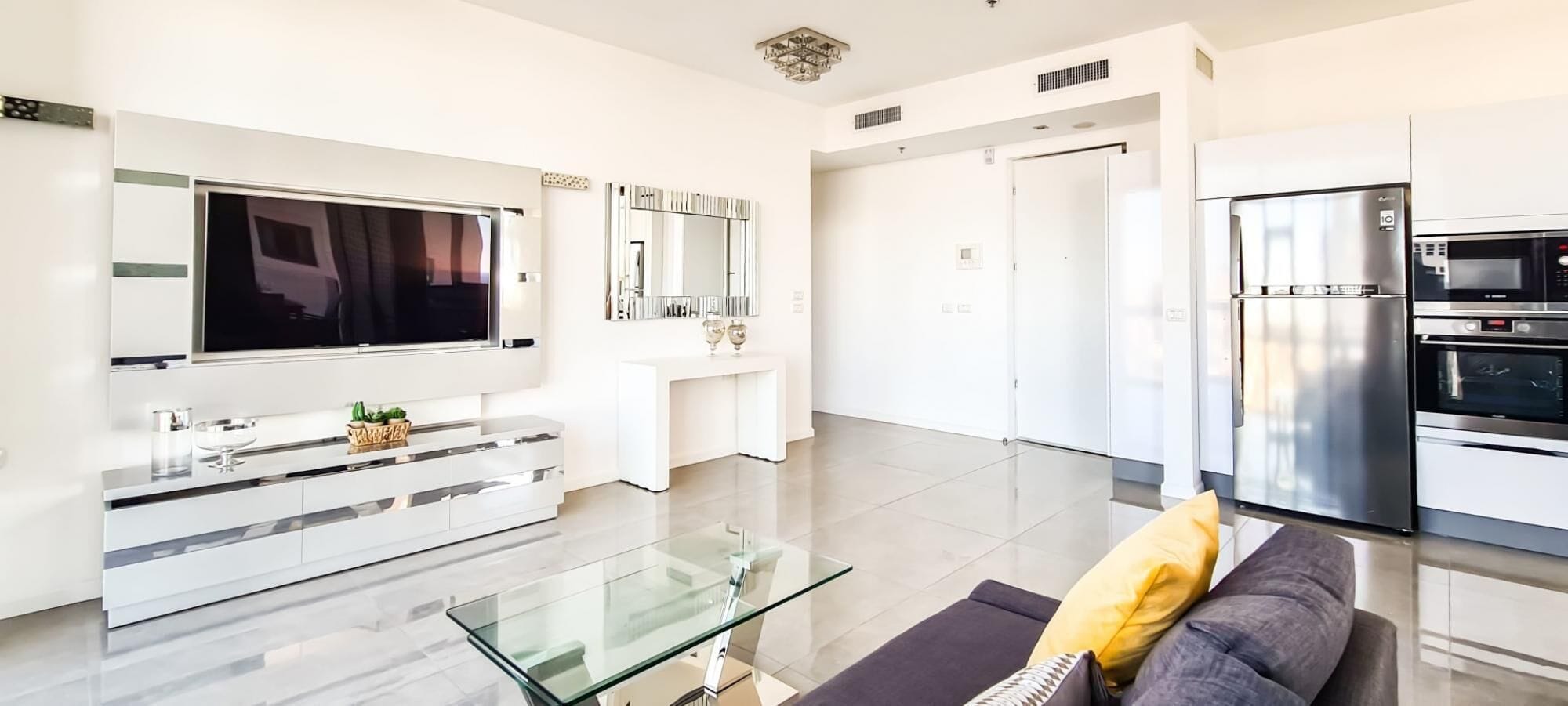 A modern kitchen with a built-in oven, microwave, and refrigerator.