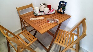 A wooden table with a tray of food items, including cookies and a bag of biscotti, and a coffee maker. - Appealing Apartment 8 Sleeps 3 Guests (Split)