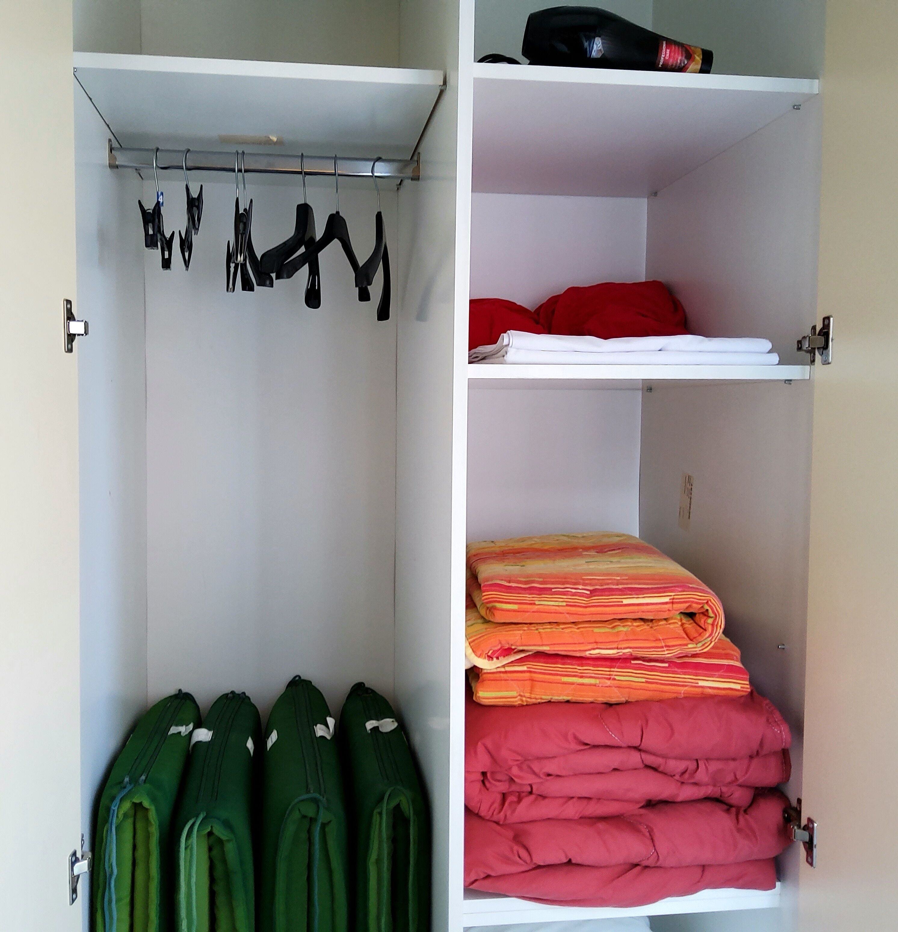 A closet with hanging space, shelves, and a folded storage area.