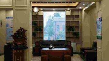 A reception area with a sofa, a table, and a decorative pillar.